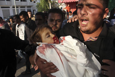 Man in Gaza, holding the body of his two-year-old child killed by an Israeli rocket
