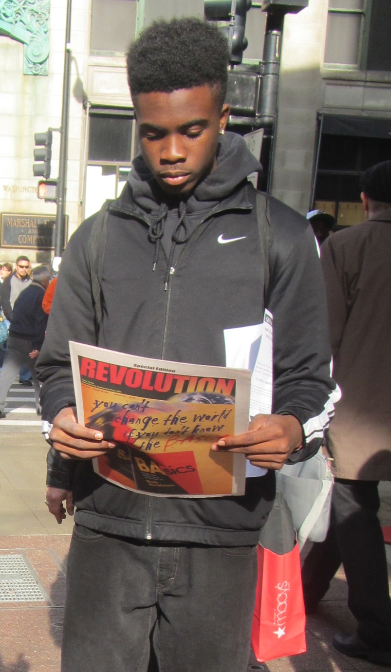 Man reading Revolution Newspaper