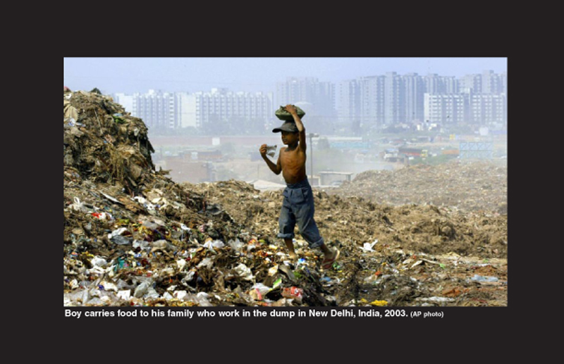 Boy carries food to his family who work in the dump in New Delhi, India, 2003