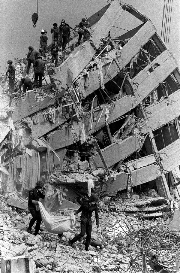 Carrying a body bag from the rubble of Mexico City's Nuevo Leon apartments, more than a week after the earthquake, September 1985.