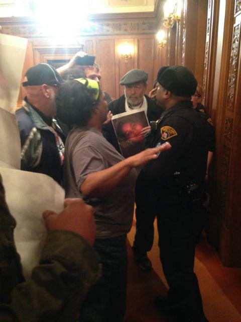 Protesters at the Cleveland City Council confront police after a member of the Revolution Club was arrested for demanding justice for Tamir Rice