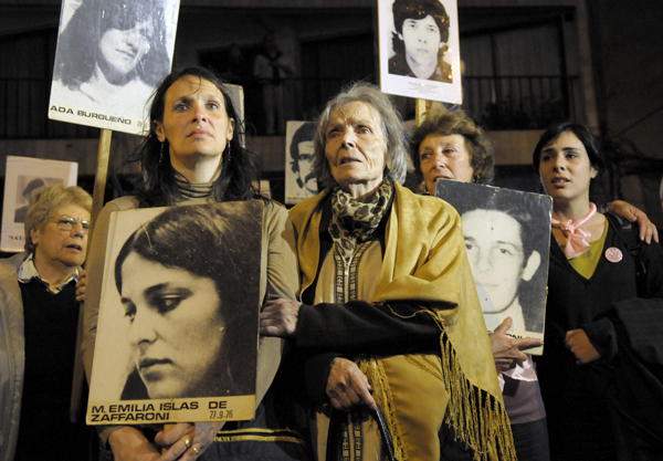 Mariana Zaffaroni Islas, front left, holds a picture of her mother during a protest in Montevideo, Uruguay in 2009. 