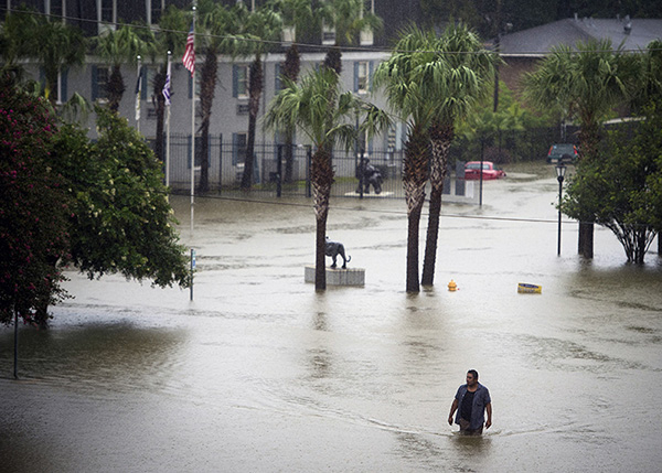 Resident wades through flood water at Tiger Manor Apartments by Louisiana State University in Baton Rouge, Aug. 13.