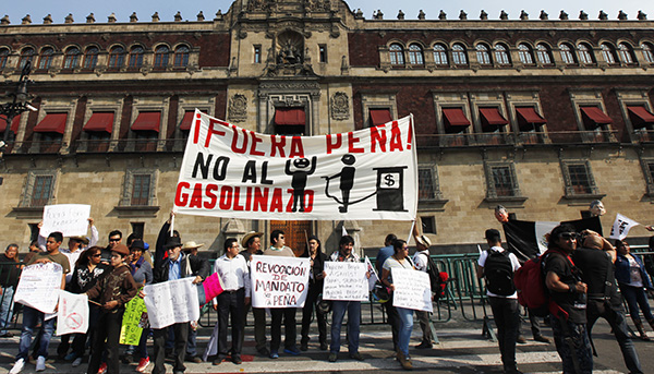 Protesters hold a sign that reads in Spanish "Pena Out! No to the gasoline price hike!" January 7