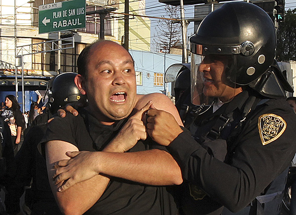 Un policía quita a un manifestante, quien junto con otros bloqueaban una calle importante por una hora durante las protestas contra el alza del precio de gasolina, Ciudad de México, 4 de enero. Al 8 de enero, la policía había arrestado a 1.500 personas y había matado a seis.