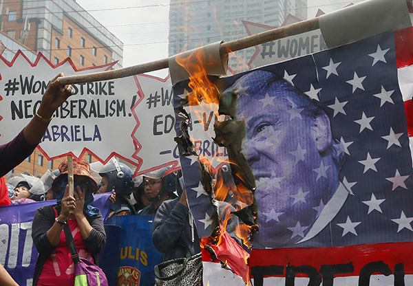 En Manila, Filipinas, los manifestantes quemaron una bandera estadounidense que llevaba la imagen de Trump.