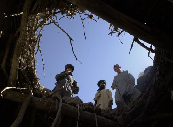Afghanis peer in hole left by US airstrike