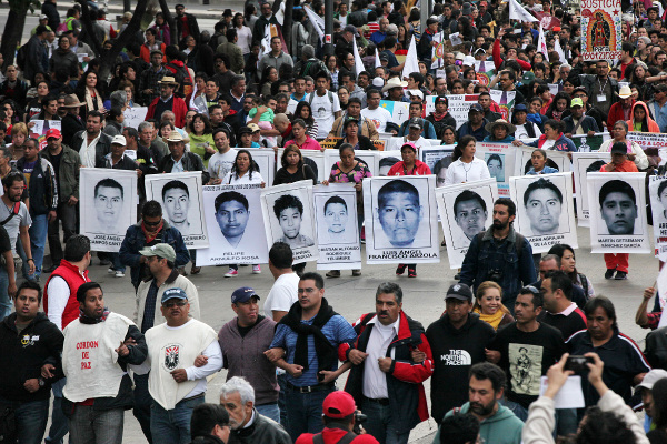 Relatives of the 43 missing students from the Isidro Burgos rural teachers college march hold pictures of their missing loved ones during a protest in Mexico City, December 26, 2014.