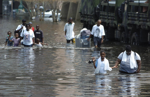 People in New Orleans who were abandoned by the system carry their possessions through the flooded streets, August 31, 2005.