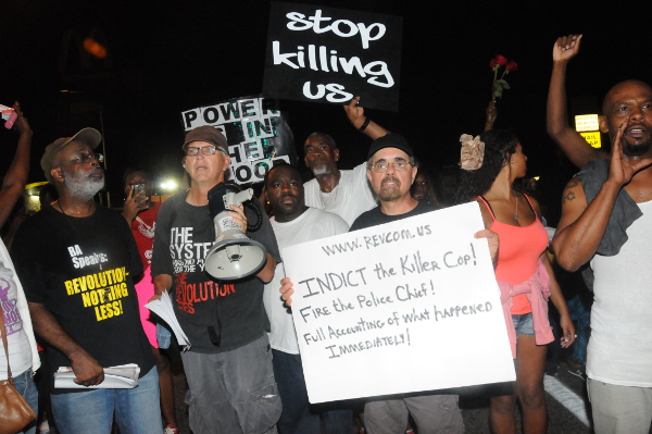 Carl Dix, Joey Johnson with bullhorn and Travis Morales with Indict the Killer Cop sign. Photo: Li Onesto/revcom.us