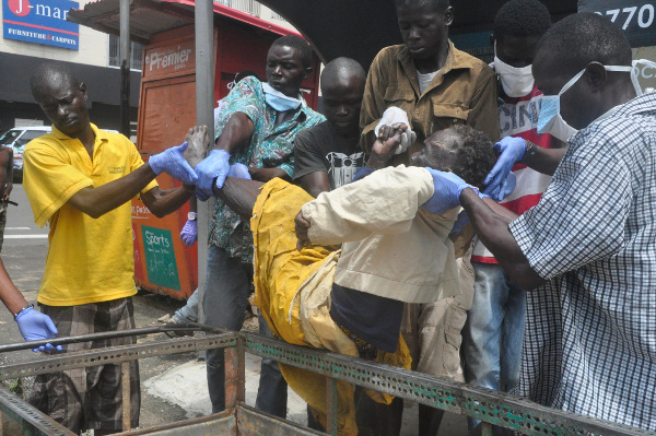 Volunteers carry patient to health center in Liberia