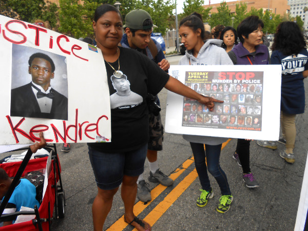 A protester carrying sign for Kendrec McDade, who was murdered in 2012 by Pasadena police