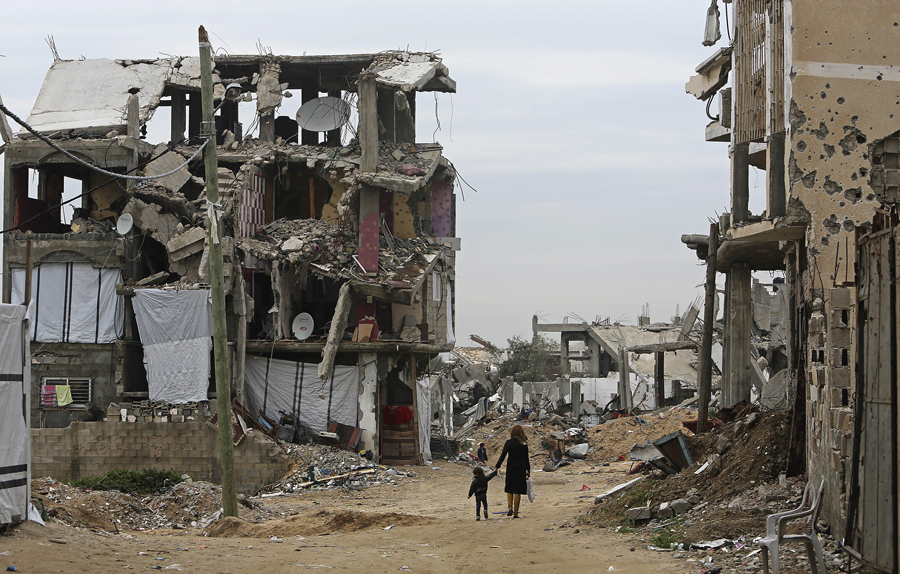Palestinians walk in the Shuja'iyya neighborhood of Gaza City, February 2015.