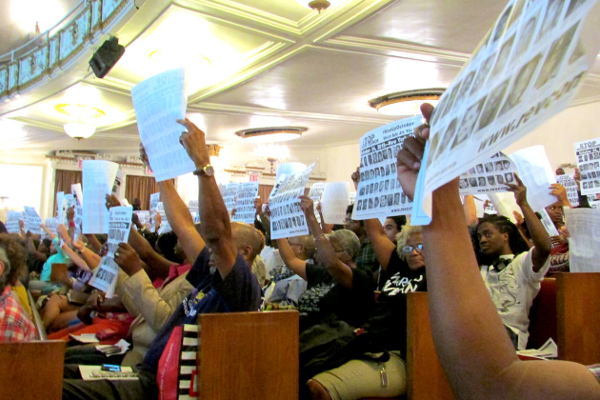 Audience raising the Stolen Lives poster