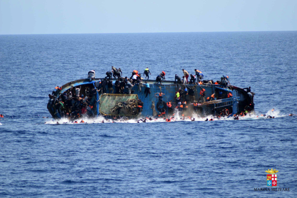 Refugees jump in the water right before their boat overturns off the Libyan coast. Since January this year the majority of people crossing the Mediterranean are from sub-Saharan Africa where wars, poverty, and repressive regimes are the driving factors pushing them out of their own countries. (Italian navy via AP Photo, file)