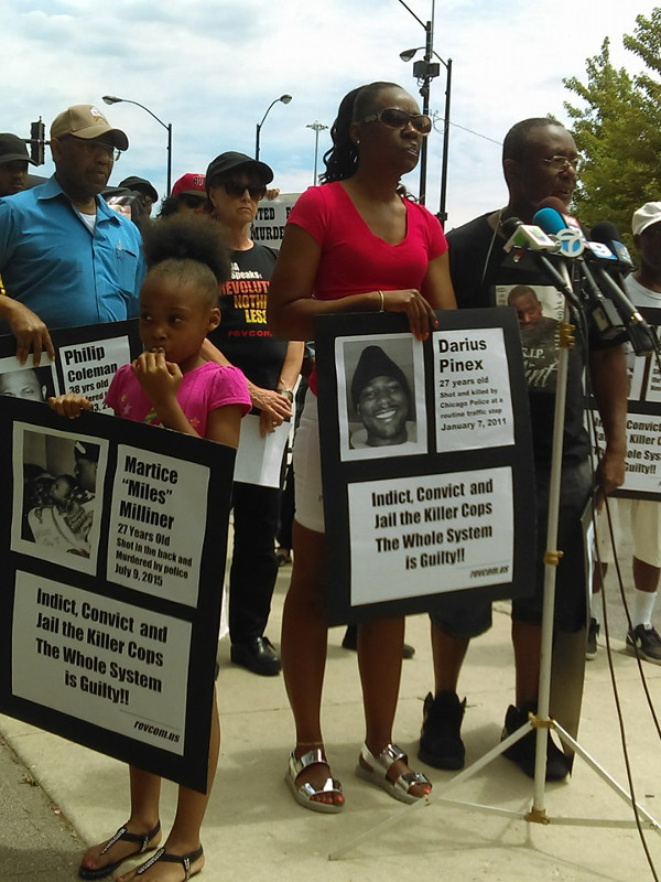 Protest against murders by police in front of the 7th District station of the Chicago Police Department, June 30. Left to right: Percy Coleman (in blue shirt); Dariana, daughter of Darius Pinex; Gloria Pinex; Emmett Farmer in black shirt with picture of his son, Flint.