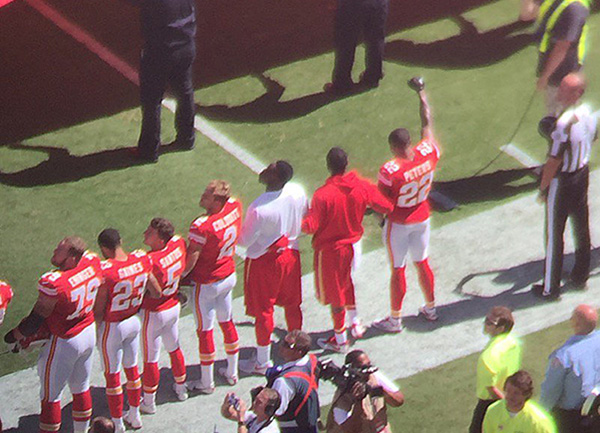 Marcus Peters raises his fist during national anthem
