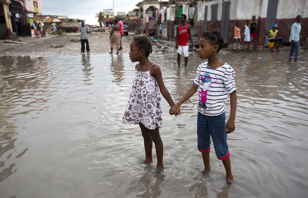 Two young girls in Les Cayes, Haiti, wade through a flooded street after the passing of Hurricane Matthew, October 6. 
