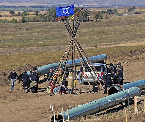 Cops drag someone from the protest to stop the digging of the Dakota Access Pipeline, October 10.