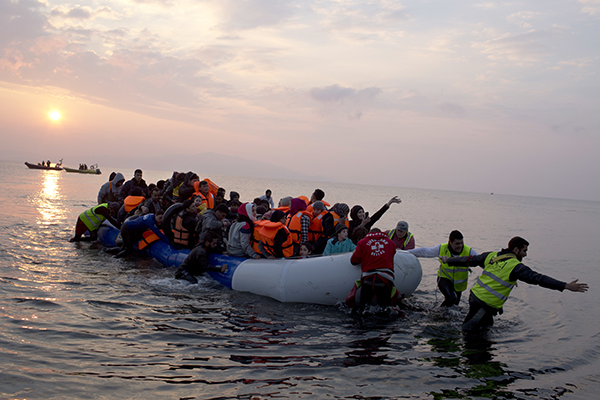 Helping migrants and refugees on a dingy as they arrive at the northeastern Greek island of Lesbos, after crossing the Aegean sea, March 2016.