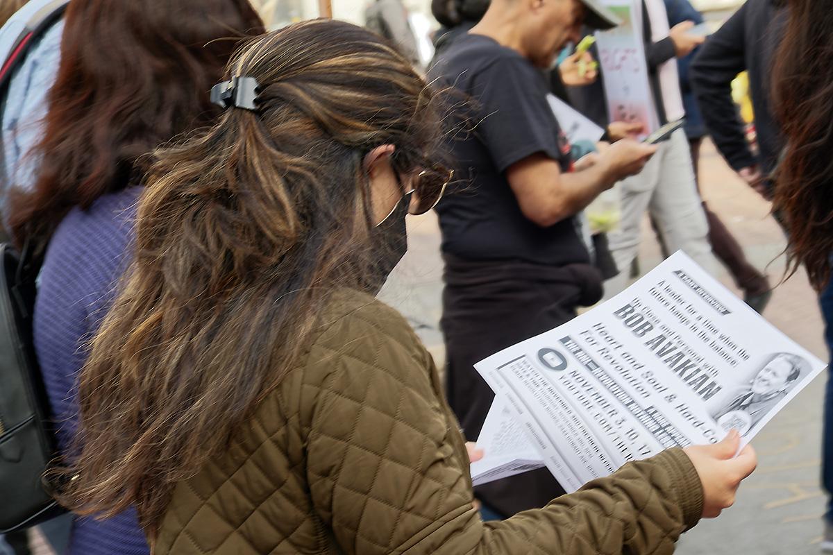 San Francisco, October 22, 2022: woman reads leaflet about Bob Avakian