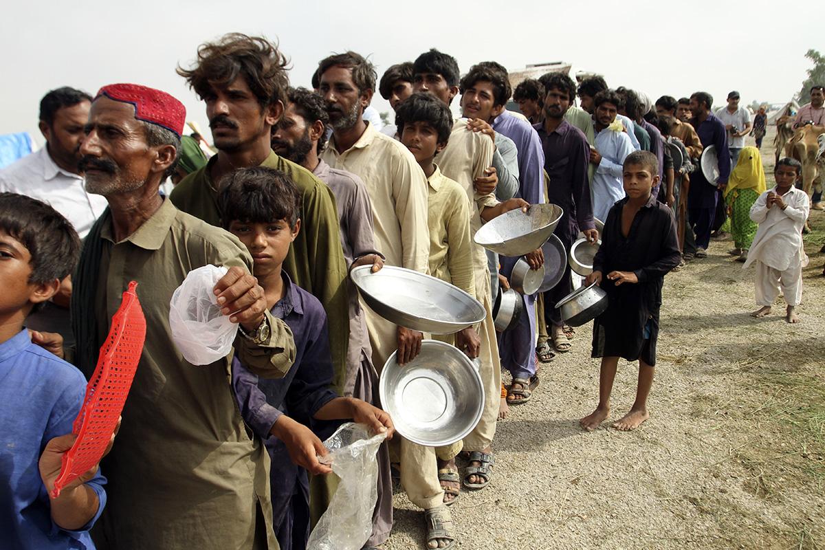 Pakistani flood victims wait in a long line for food distribution, August 27, 2022.