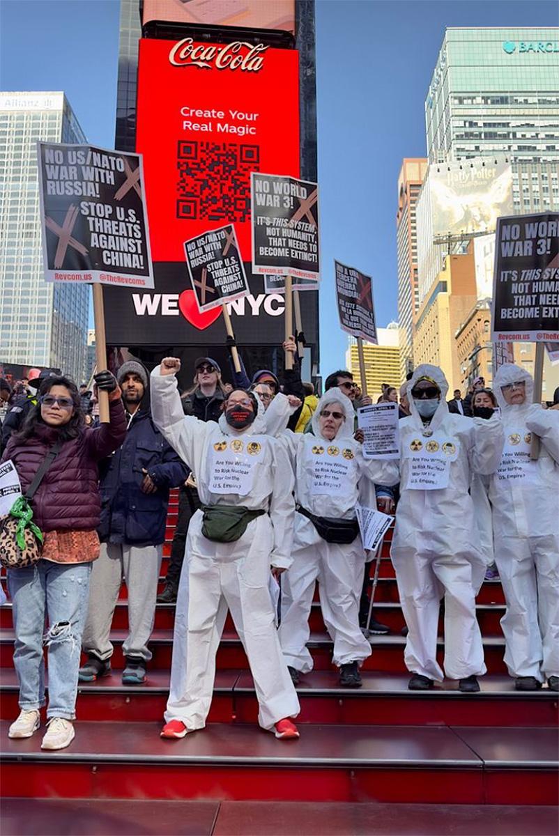 Protesters in Hazmet suits say No World War 3! at the Red Stairs, Times Square, 