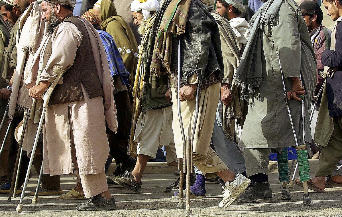 A group of amputees, many the victims of land mines, march in Kandahar.