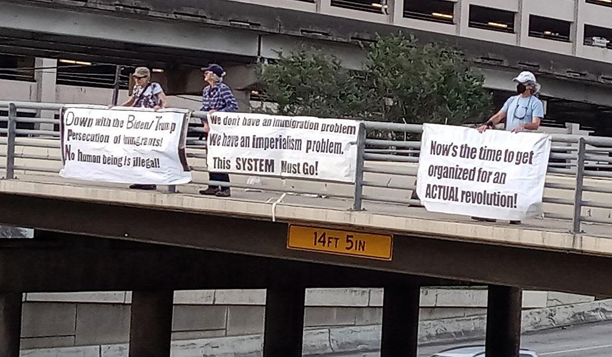 During morning rush hour, we held up banners with the three slogans about immigration on a bridge over a busy freeway near downtown Houston, May 12, 2023.