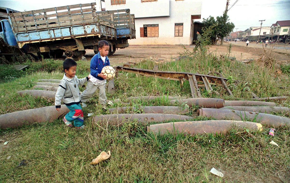 Children play near cluster bombs in Laos, 1997.