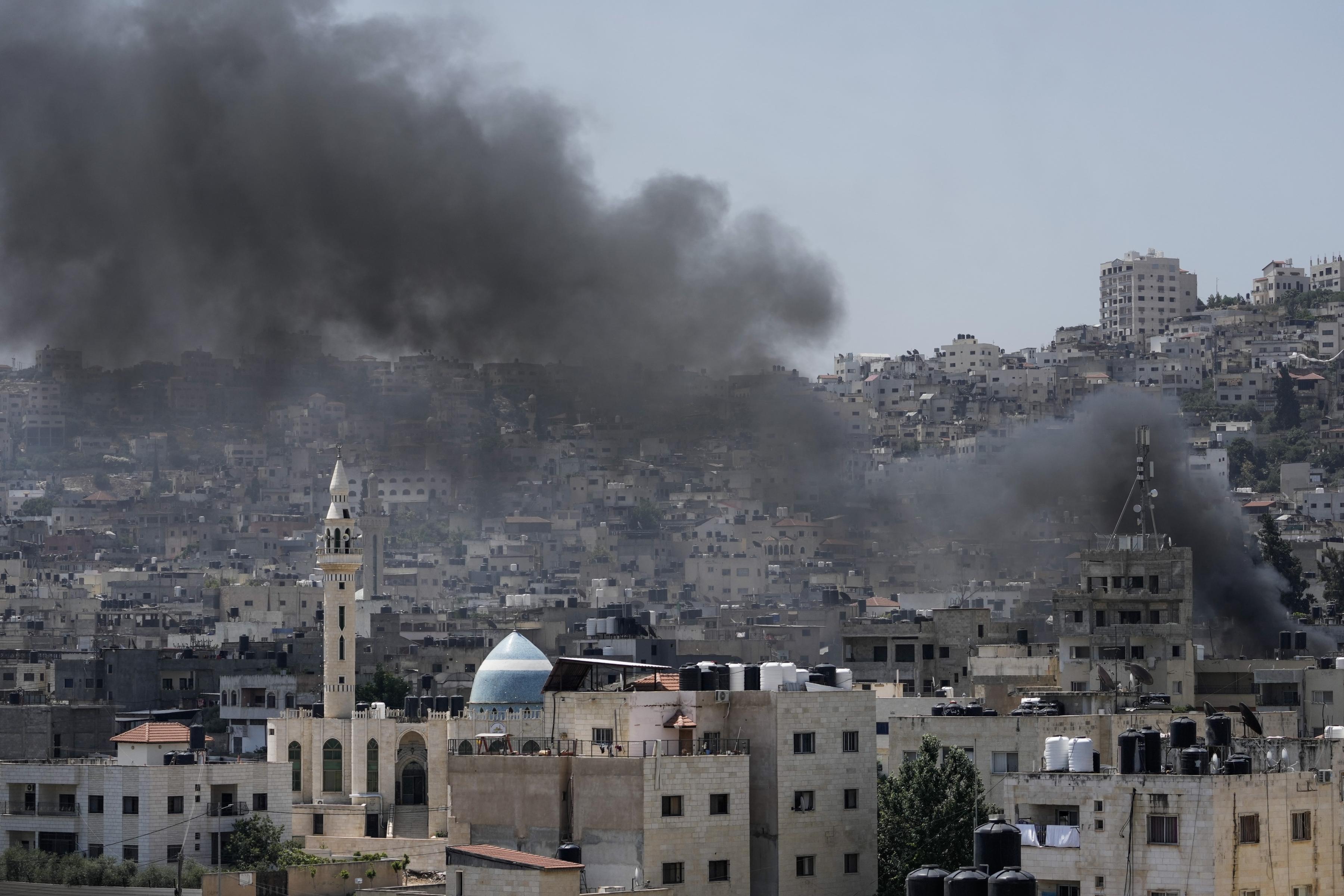 Smoke rises from a densely occupied area of homes in Jenin during Israeli assault on Jenin