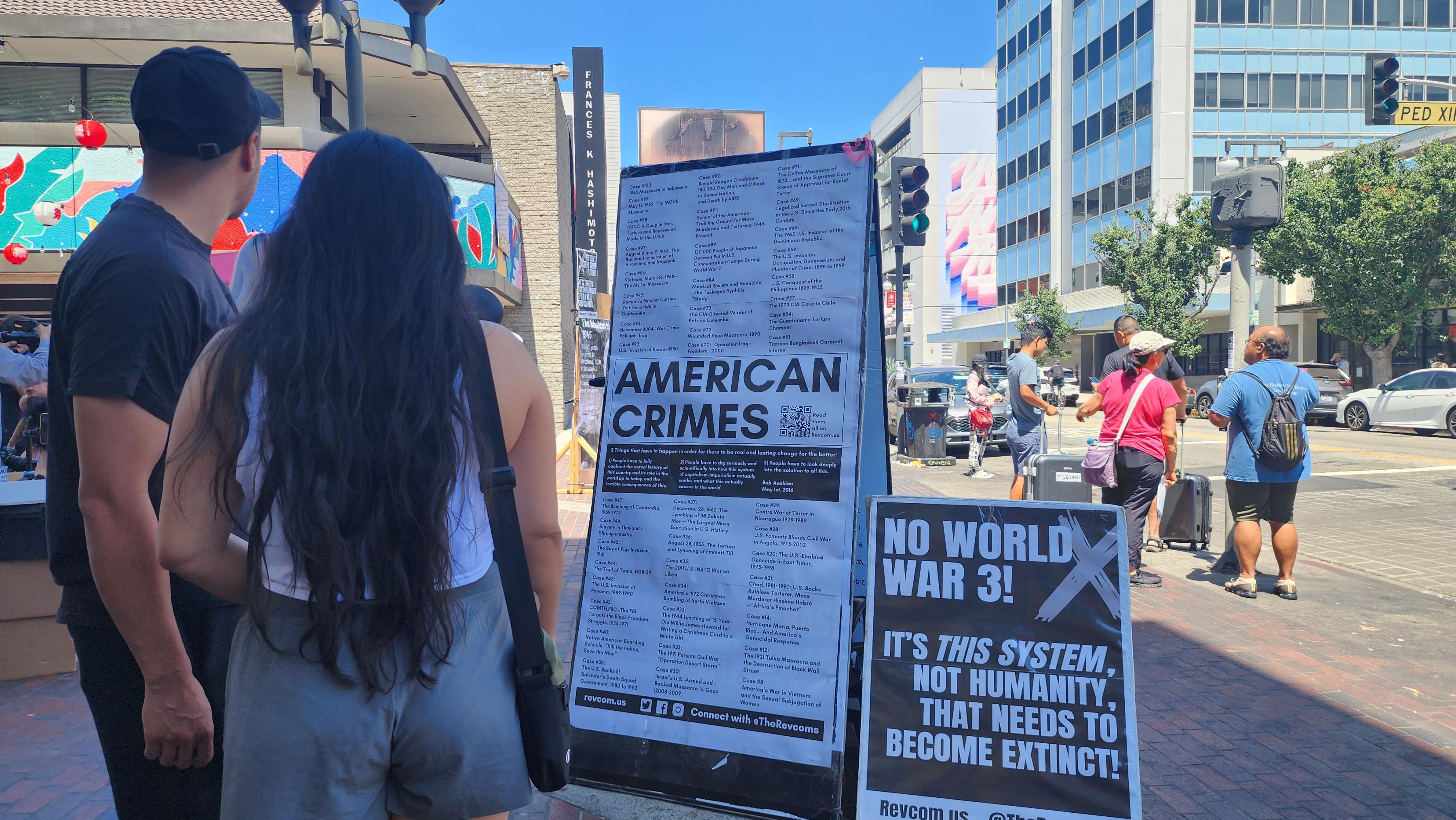 Two people reading poster of American Crimes