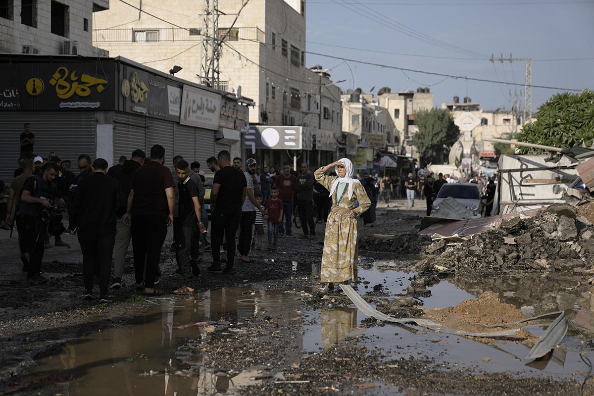 Woman looks down the street of Jenin refugee camp in the West Bank destroyed by Israeli airstrike on October 30, 2023.