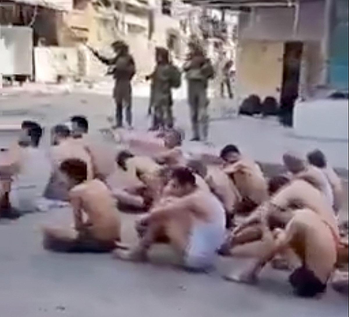 Israeli soldiers guard Gaza prisoners who have been stripped to their underwear.