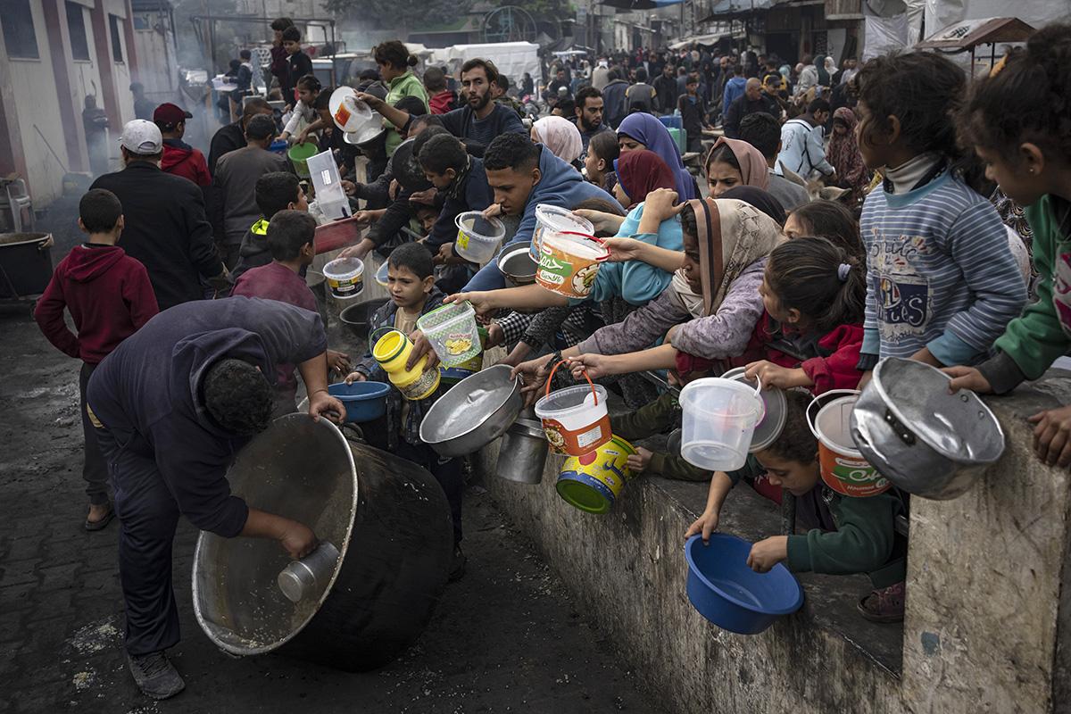 Starving people in Gaza crowd with pans for food, December 21, 2023.