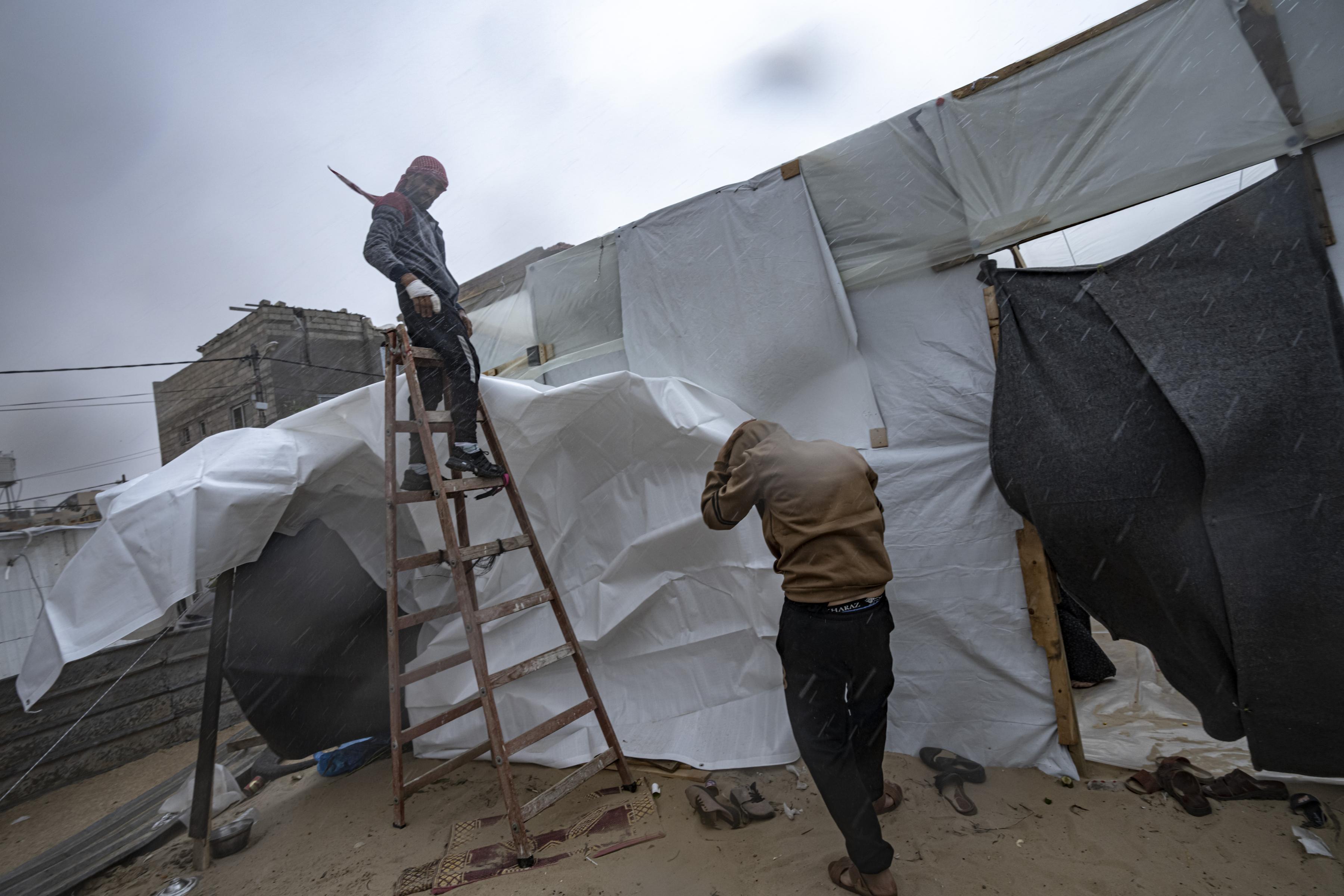 Building tents in the rain in Gaza winter near Khan Younis