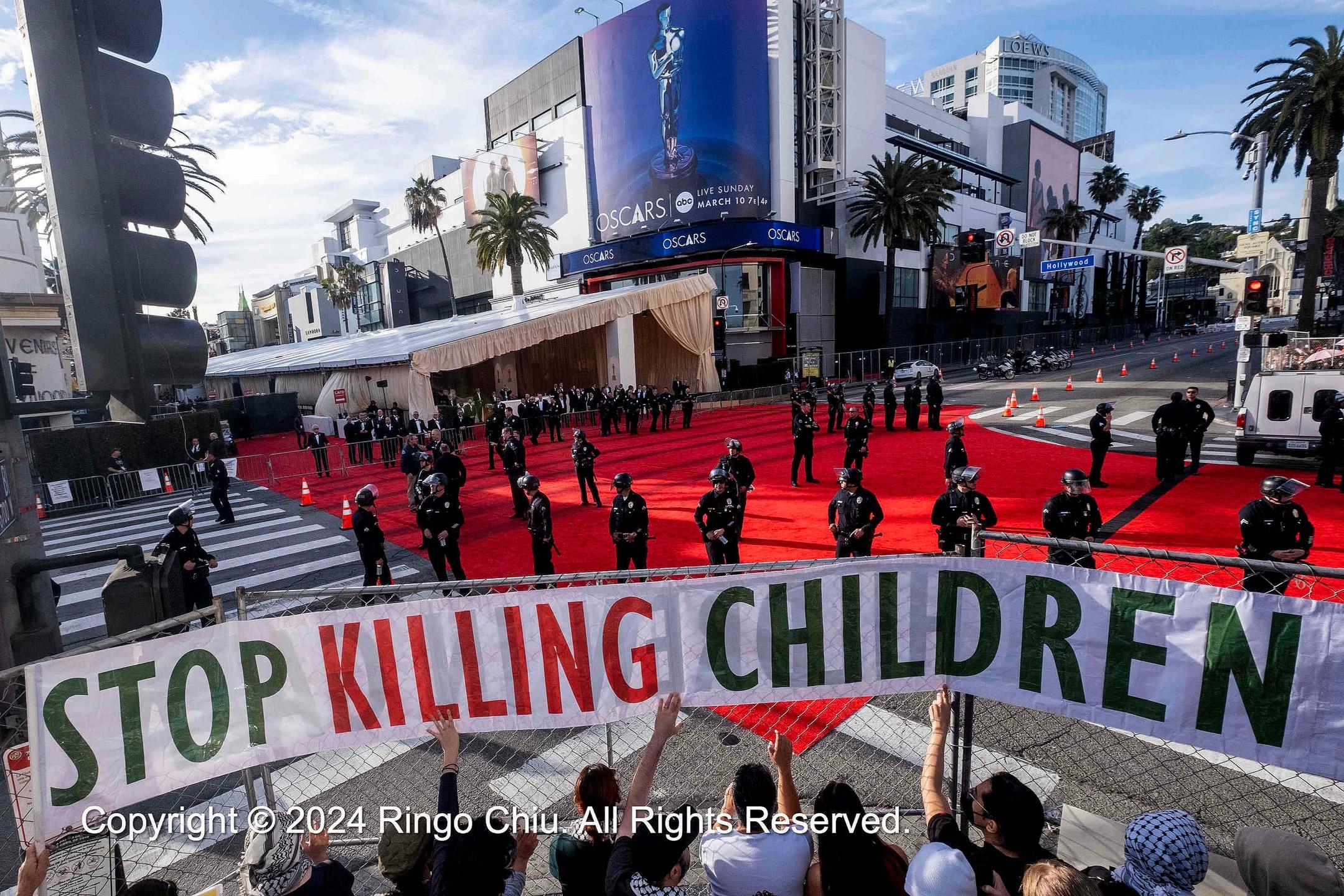 Stop Killing Children banner across the street from the Academy Awards