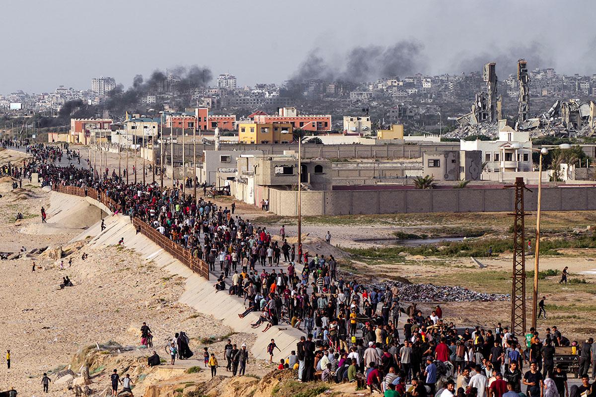 Thousands of Palestinians wait for aid trucks to cross into central Gaza Strip, May 19, 2024.