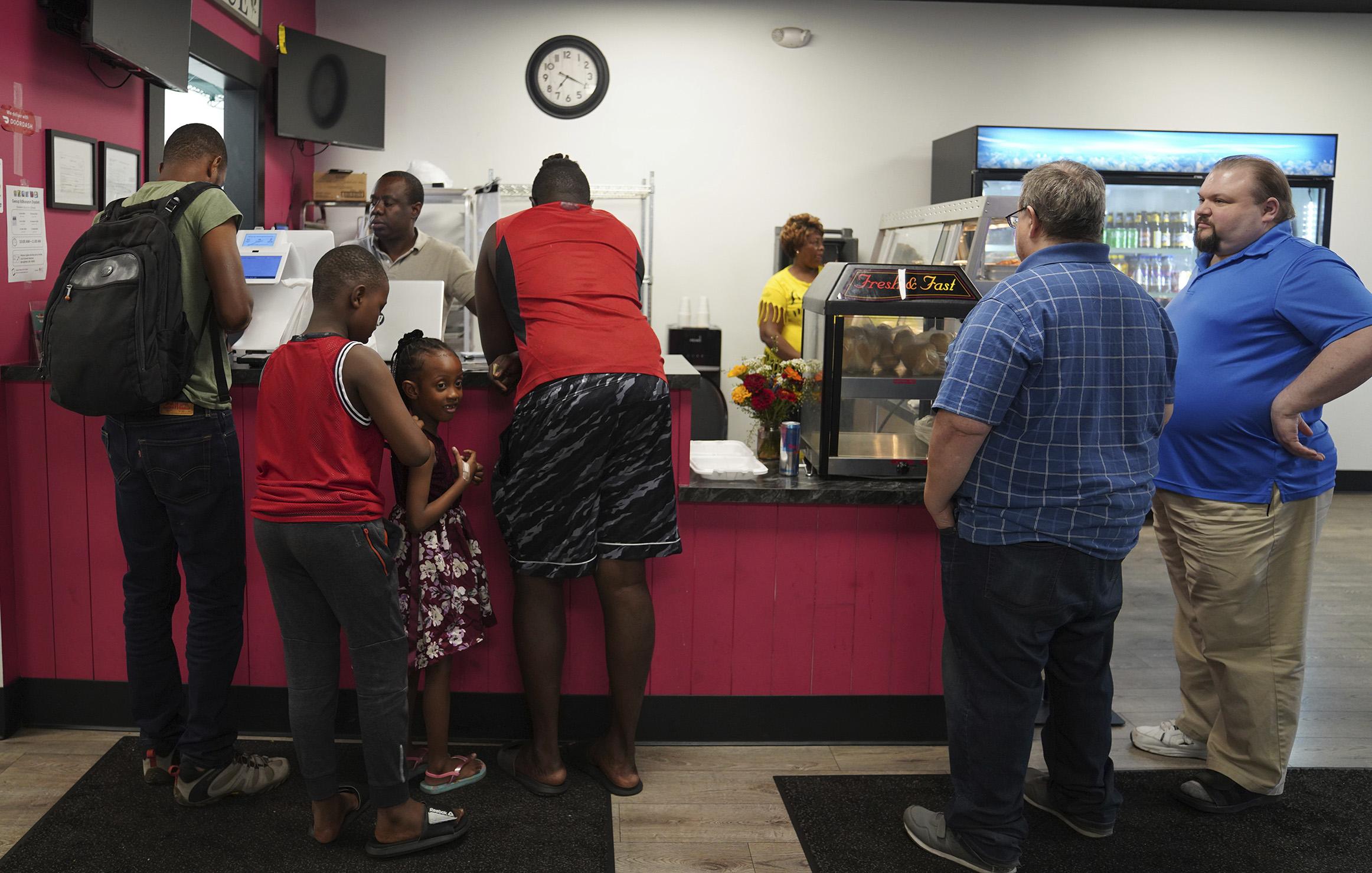 Haitian at Rose Goute Creole Restaurant in Springfield, Ohio, helps a line of customers, September 16, 2024.