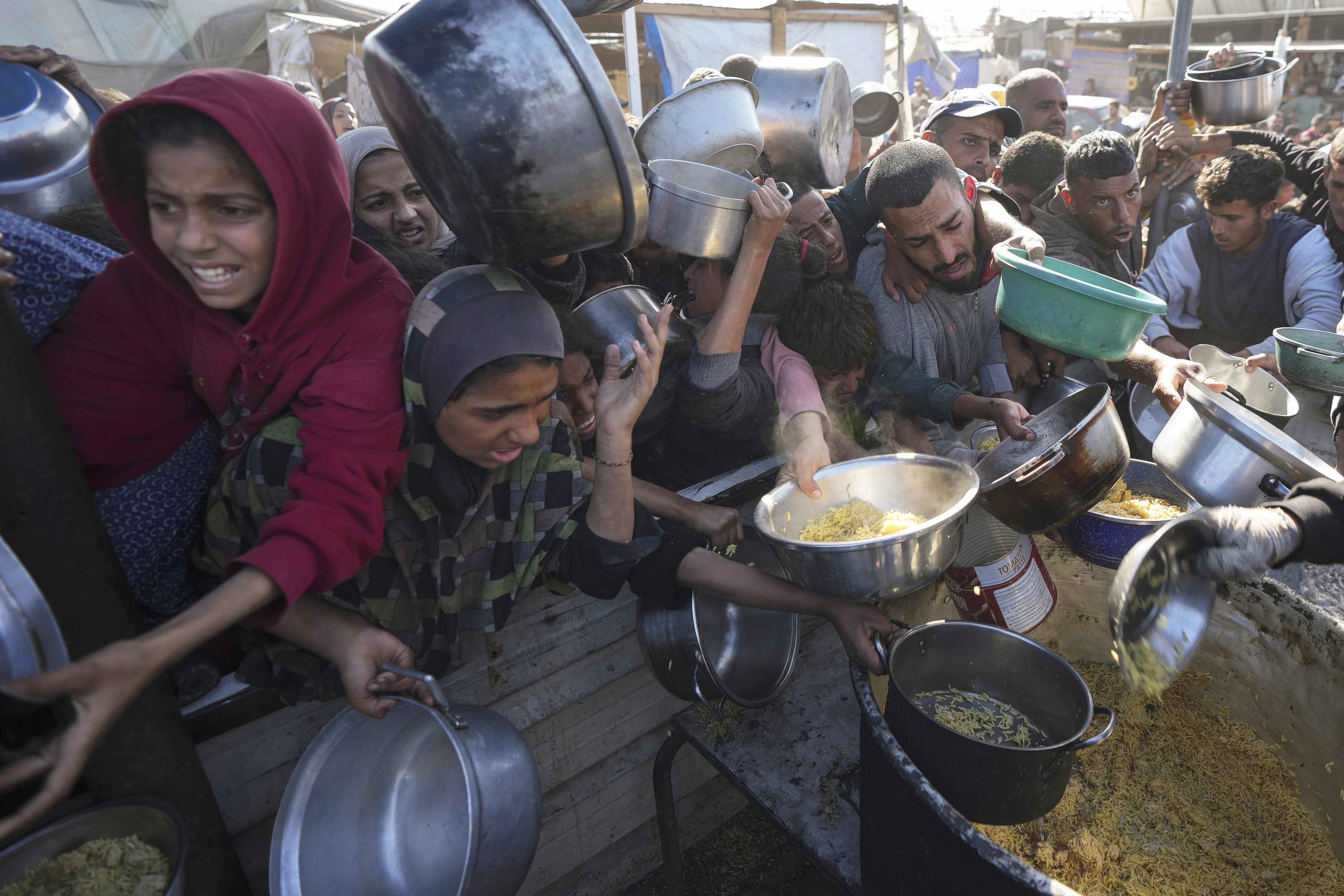 Impending famine in Gaza: Here Palestinians queue at a food distribution center in Khan Younis, December 6, 2024. 