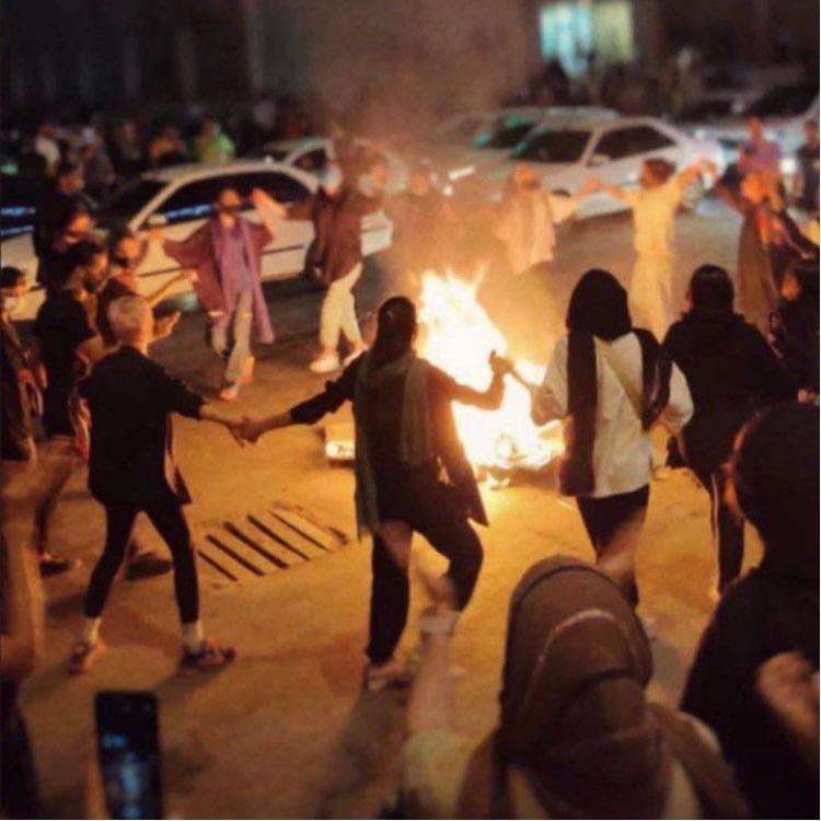 Women dance around a bonfire of burning headscarves, Bandar Abbas, Iran, September 22, 2022. 