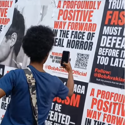 A woman scanning the QR code on a Bob Avakian Official poster.