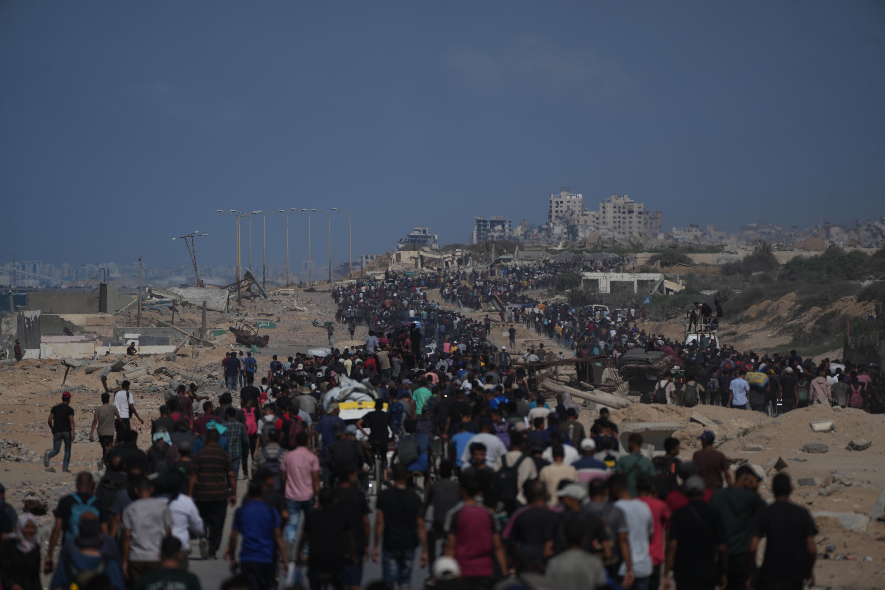 Palestinians walk with their belongings along the coastal road in the central Gaza Strip, moving toward Gaza City, Friday, Oct. 10, 2025