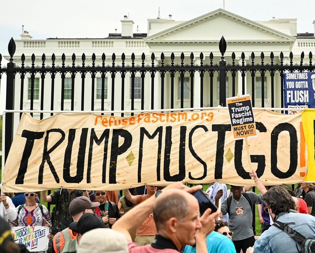 Refuse Fascism banner "Trump Must Go Now" in front of the White House gates.