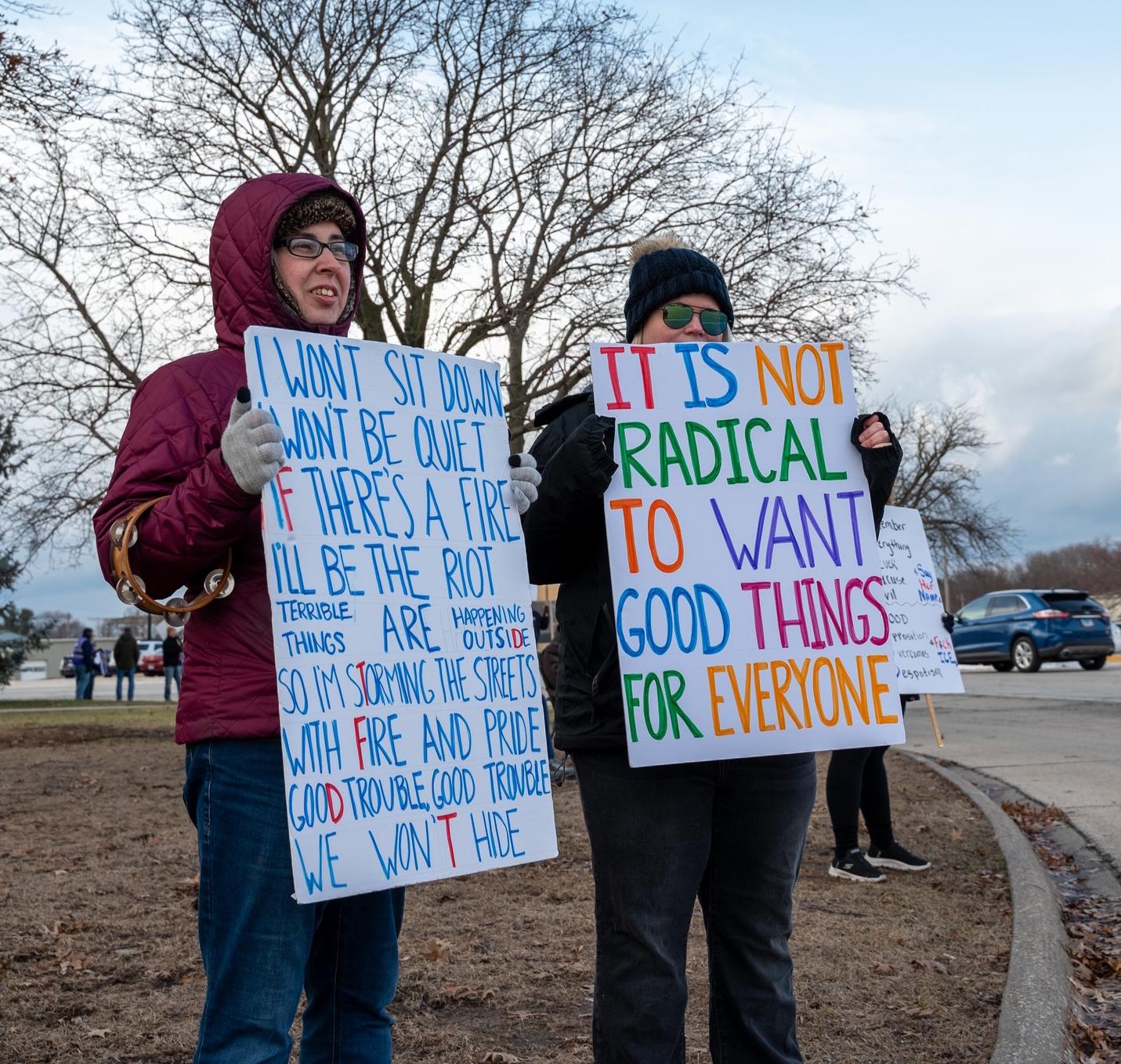 2 people holding protest signs in Galesburg, Illinois.