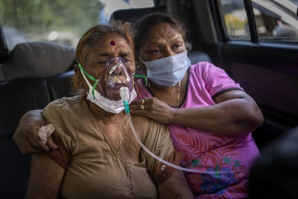 Covid patients in India waiting in cars share oxygen supply.