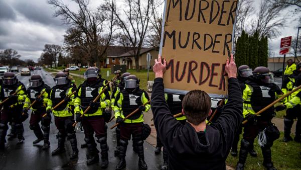Protesters confront cops. Sign says: "Murder, murder, murder." Brooklyn, Minnesota