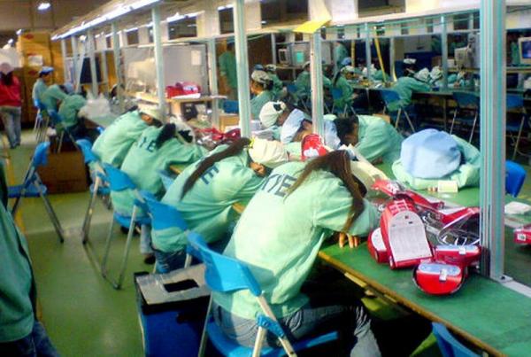 China women sleep at their factory workstations 