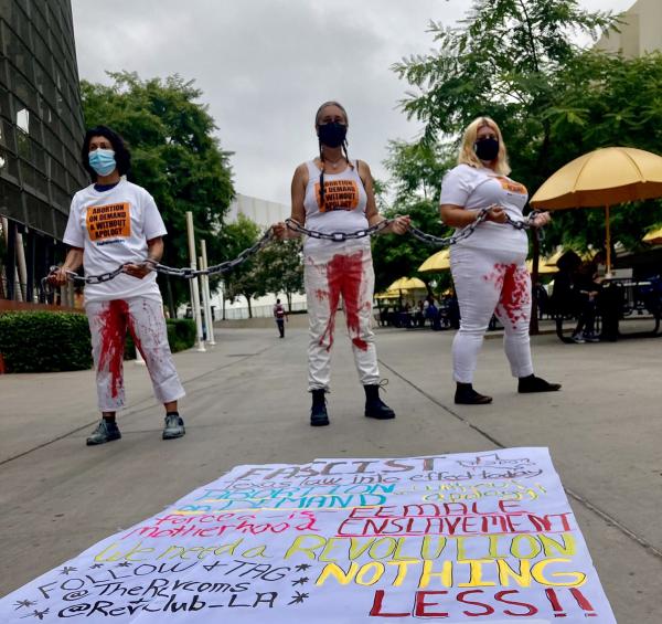 Three women on LA campus with bloody pants and pro abortion sign 
