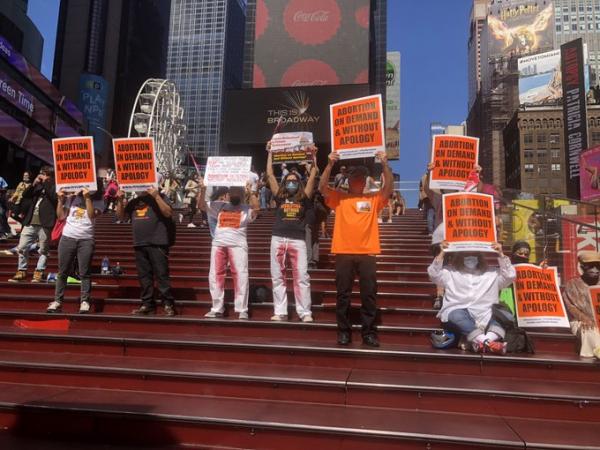 NYC Rev Club on the "red steps" in Times Square with signs: Abortion On Demand and Without Apology